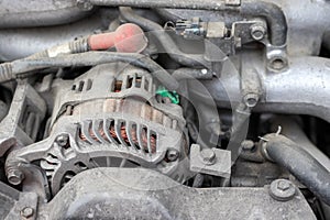 Alternator. Dusty details of a flat-four boxer car engine compartment under the open hood