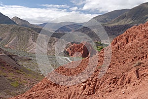 Altiplano. The arid desert and colorful mountains. View of the hiking path across the canyon. The orange sandstone