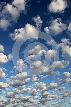 Altocumulus white puffy fluffy clouds against deep blue sky