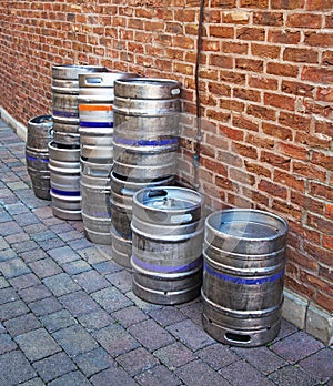 Aluminium Beer Barrels Against a Brick Wall