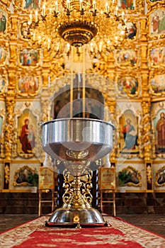 Aluminium church font, large bowl, with golden cross and saint water for the baptism of babies in Orthodox Church temple