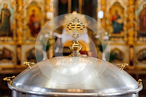 Aluminium church font, large bowl, with golden cross and saint water for the baptism of babies in Orthodox Church temple