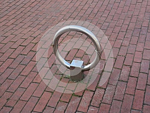 Aluminium ring on a brick stone sidewalk