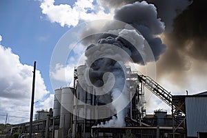 aluminium smelter with smoke and flames billowing out of stack