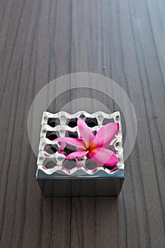 Aluminum ashtray and pink flower