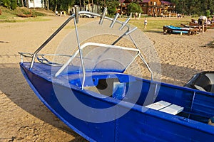 Aluminum blue fishing boat with a motor near the lake shore, fishing, tourism, active recreation, lifestyle