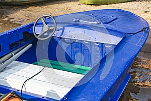 Aluminum blue fishing boat with a motor near the lake shore, fishing, tourism, active recreation,steering wheel