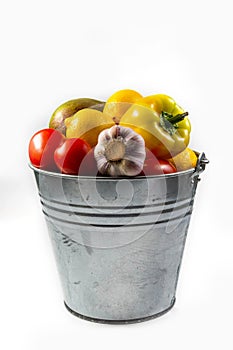 .Aluminum bucket with assortment of fresh vegetables on white background