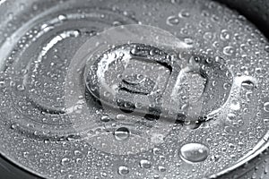 Aluminum can of beverage covered with water drops as background