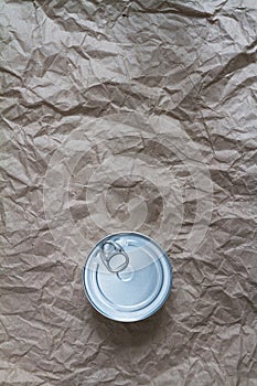 Aluminum can with key on craft paper, background