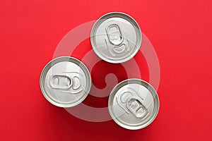 Aluminum drink or beverage cans with pull ring on red background