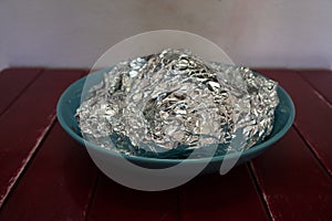 Aluminum foil and bowl on table