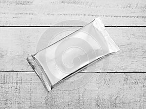 Aluminum foil package on wood background