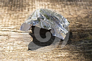 aluminum foil wrap without chocolate candy on a wooden background. Texture of used crumpled aluminium food foil.