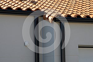 aluminum grey gutter on modern roof of the building and gray downpipe on facade wall home