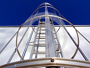 aluminum roof access ladder with safety cage in diminishing perspective.