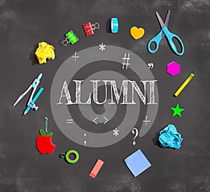 Alumni theme with school supplies on a chalkboard