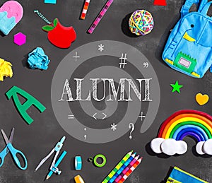 Alumni theme with school supplies on a chalkboard