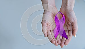 Alzheimer`s Disease AD Awareness with purple ribbon clipping path on human helping hand for World Alzheimers day month