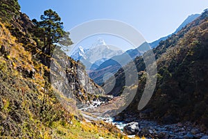 Ama Dablam mountain snow peaks, Imja Khola gorge canyon river. photo