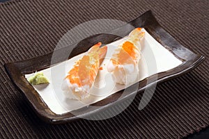 Amaebi sushi with wasabi on ceramic dish, sweet boiled shrimp wi