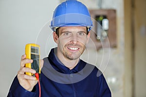 amale electrician showing multimeter