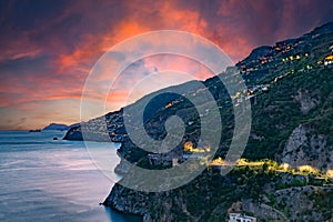 Amalfi Coast, Italy. View over Praiano on the Amalfi Coast at sunset. Street and house lights at dusk. In the distance the island