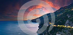 Amalfi Coast, Italy. View over Praiano on the Amalfi Coast at sunset. Street and house lights at dusk. In the distance the island