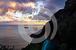 Amalfi - Woman enjoying the sunset over island of Mediterranean sea on Amalfi Coast in Italy, Europe.