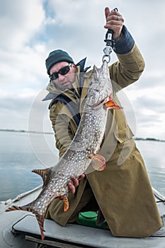 Amateur angler holds big pike fish