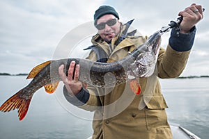 Amateur angler holds big pike fish