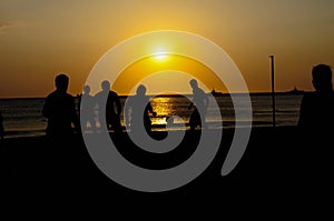 Amateurs playing football at Jumeira beach in Santa Marta, Colombia during sunset photo