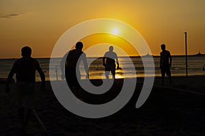 Amateurs playing football at Jumeira beach in Santa Marta, Colombia during sunset photo