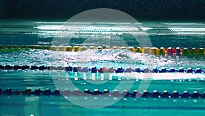 Amator female athlete doing butterfly stroke during training in indoor swimming pool, slow motion, full HD steady shot