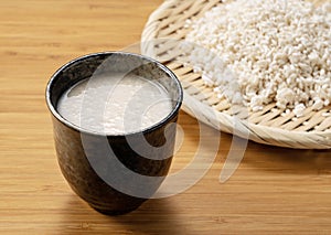 Amazake on the table and rice malt in a colander