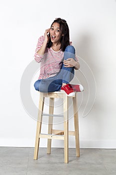 Amazed 20s multi-ethnic girl laughing on her cell phone