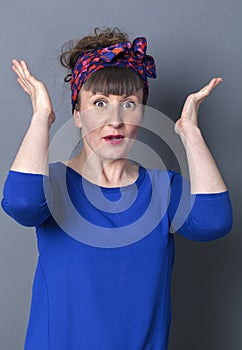 Amazed 30s woman with retro hairstyle smiling with arms up