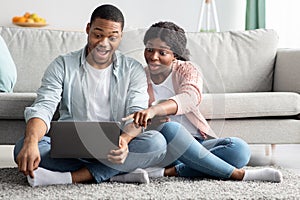 Amazed african american couple using laptop at home