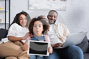 amazed african american girl showing digital