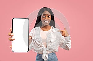 Amazed african american woman showing big smartphone with blank screen