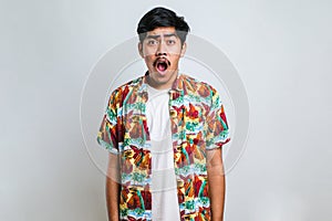 Amazed asian young man with open mouth and bulging eyes looking at camera