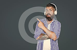 amazed bearded man listen to music pointing finger on headphones