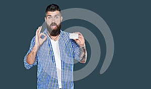 amazed bearded man showing blank debit card with copy space