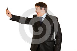 Amazed businessman yelling on mobile phone