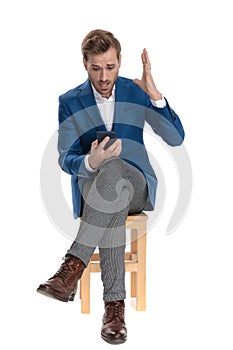 Amazed casual guy looking to his phone and screaming