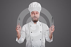 Amazed chef with knife and fork