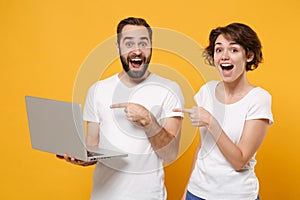 Amazed couple friends bearded guy girl in white blank empty t-shirts isolated on yellow orange background. People