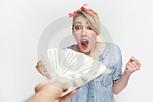 Amazed excited surprised woman standing getting big sum of money, looks with open mouth.