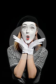 Amazed female mime on black. Vertical portrait of pantomime actress