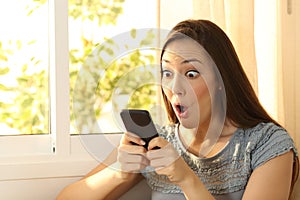 Amazed girl watching content on smart phone